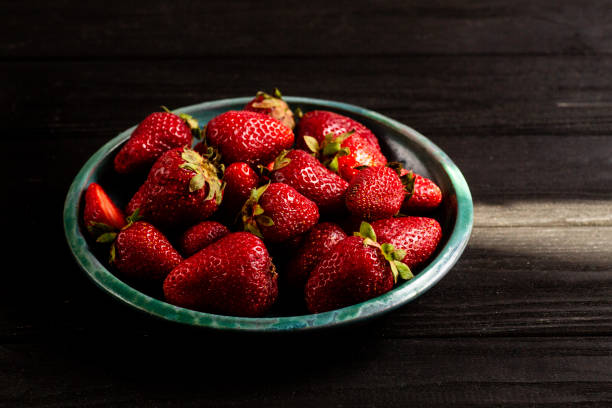 istock Fresh strawberries on a plate against black background 967910232