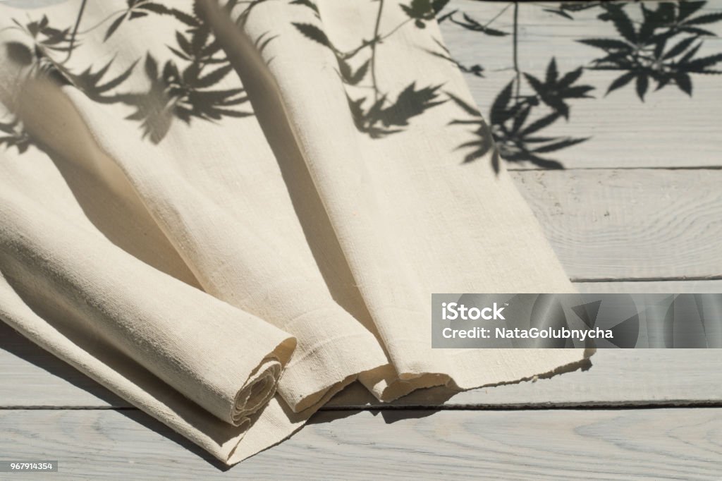 Hemp fabric on a white wooden surface Hemp homespun fabric on a white wooden surface Hemp Stock Photo