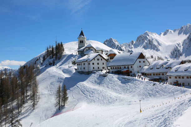 Lussari Mountain, UD, Italy - April 1, 2018: breathtaking view of the ancient Sanctuary and more buildings with snow in spring