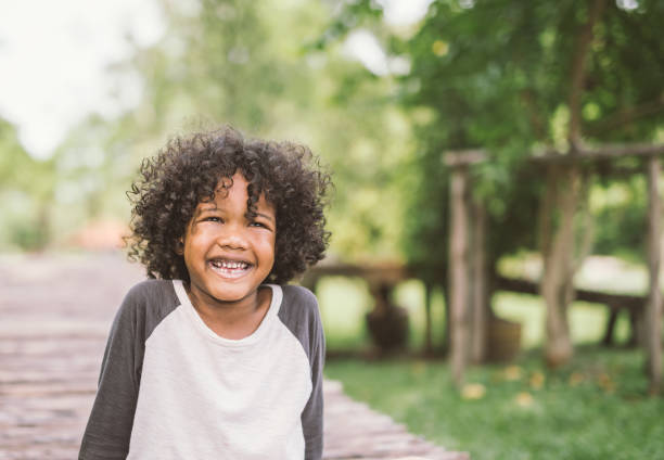 retrato de um americano africano menino bonitinho sorrindo. - child autumn nature human face - fotografias e filmes do acervo