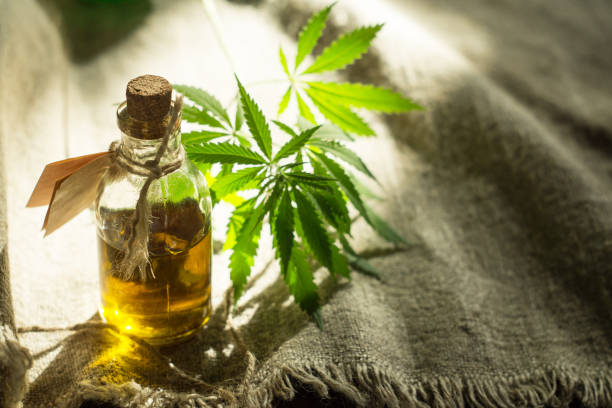 istock Hemp oil, canvas and threads on a dark wooden surface 967917410