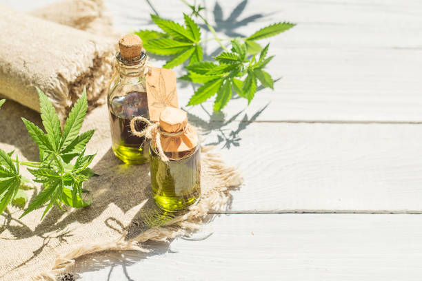 istock Hemp oil, canvas and threads on a white wooden surface 967917700