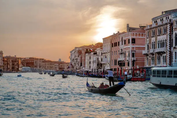 The sun sets over gondolas and other water traffic on the Grand Canal, Venice