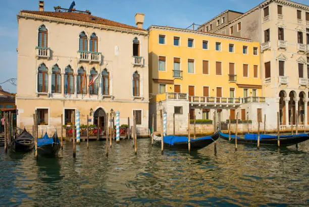 Colorful buildings and parked gondolas along Venice's Grand Canal.