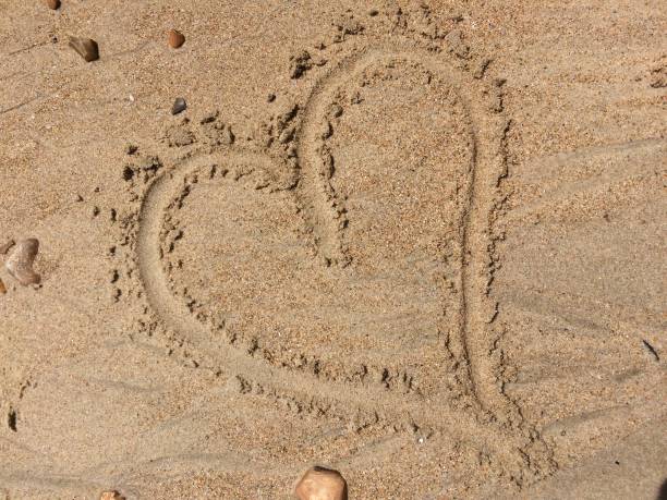istock Love heart in the sand 967930754