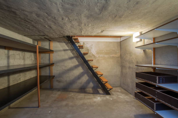 empty basement in abandoned old industrial building with little light and a wooden stairs stock photo