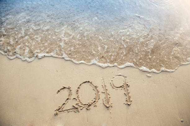 istock 2019 written at the sandy beach with sea wave water 967948520