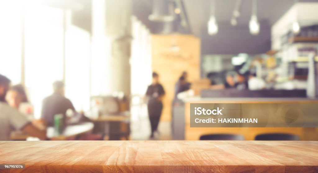 Wood table top with blur of people in coffee shop or (cafe,restaurant )background Wood table top with blur of people in coffee shop or (cafe,restaurant )background.For montage product display or design key visual layout Cafe Stock Photo