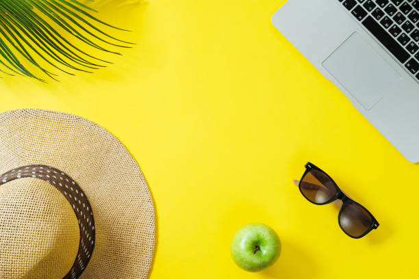 istock Working space: Laptop, palm leaf, clipboard hat on a yellow background. Top view, flat lay, space for text 967953460
