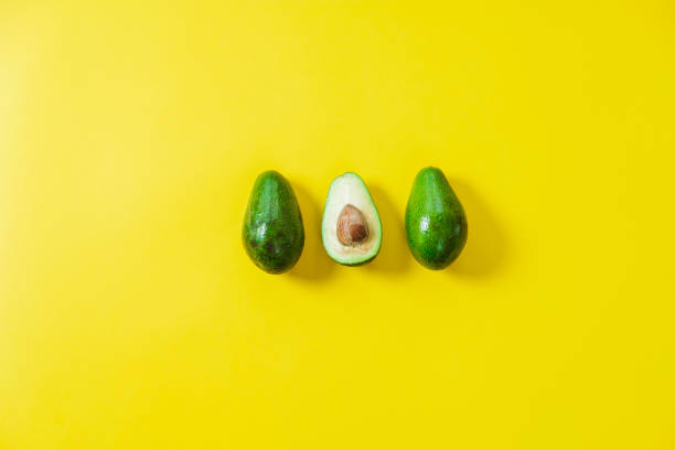 istock A few sliced avocados on a yellow background. Top view, flat lay, space for text