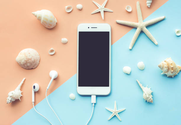 istock Top view of smartphone and seashell  on color background. 967953896