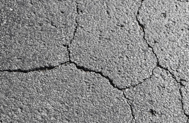 Cracked asphalt - shades of grey - background element