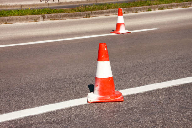 istock Work on road. Construction cones. Traffic cone, with white and orange stripes on asphalt. Street and traffic signs for signaling. Road maintenance, under construction sign and traffic cones on road. 967969260