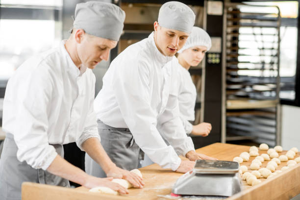 istock Bakers forming dough for baking at the manufacturing 967969320