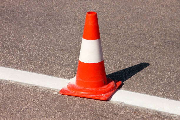 istock Work on road. Construction cone. Traffic cone, with white and orange stripes on asphalt. Street and traffic signs for signaling. Road maintenance, under construction sign and traffic cone on road. 967969412