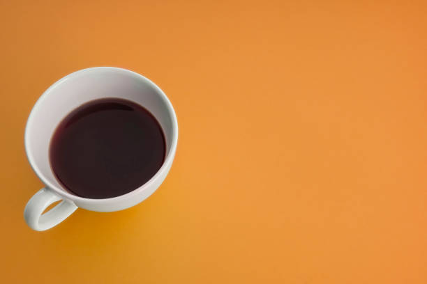 istock A cup of coffee with headphone on orange background 967976886