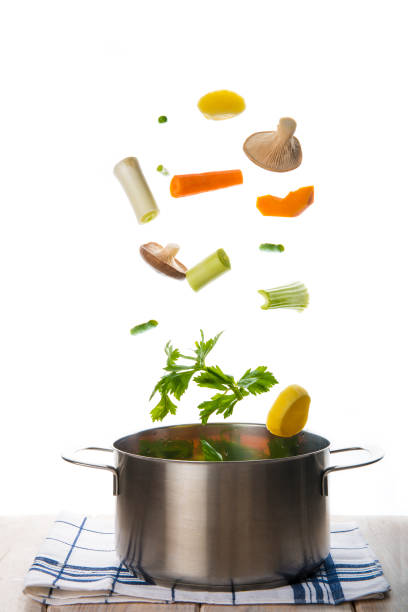 istock Fresh vegetables falling into a pot isolated on a white background 967977092