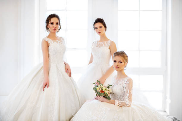istock Young woman with bouquets wearing wedding dresses 967979906