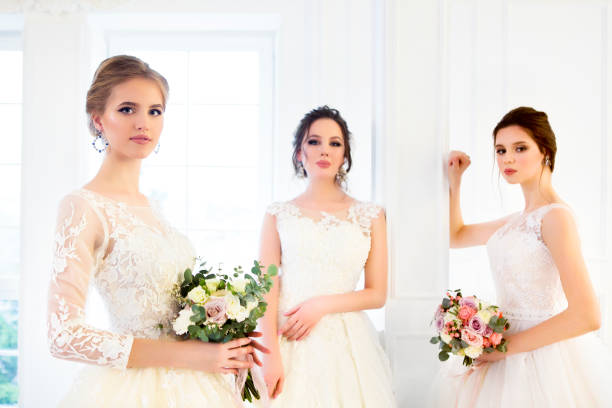 istock Young woman with bouquets wearing wedding dresses 967979942