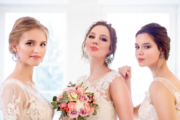 istock Young woman with bouquets wearing wedding dresses 967979944