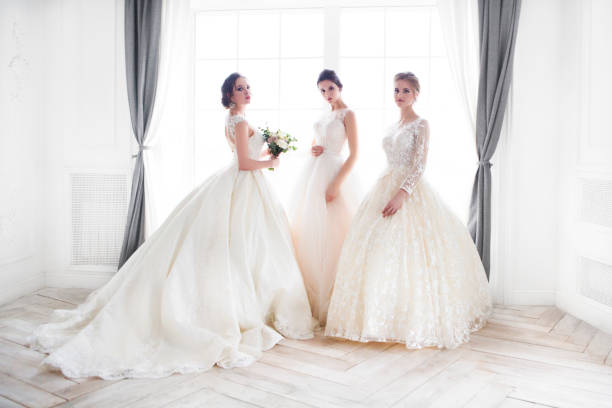 Young woman with bouquets wearing wedding dresses Three young woman with bouquets wearing wedding dresses bridal boutique stock pictures, royalty-free photos & images