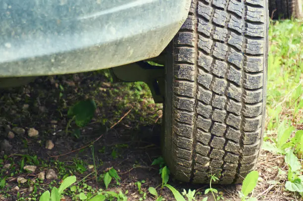 Photo of Wheel from a car close-up against a background of green grass. Abstract background.