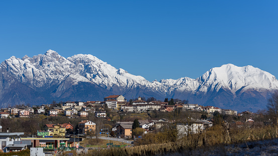 Mel (Belluno), Italy - February 11, 2016: View of Mel in the province of Belluno with the background of the snowy Veneto Dolomites