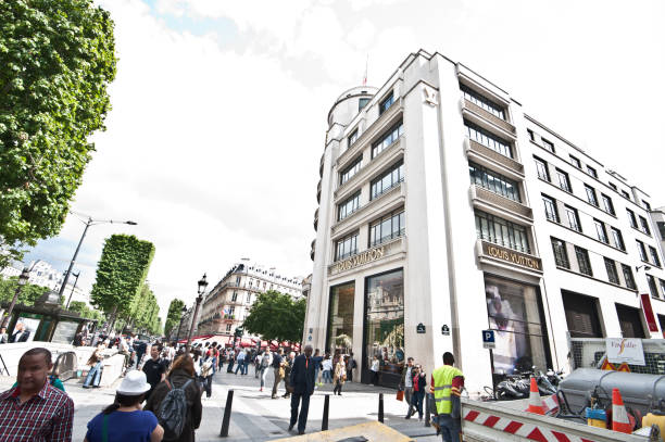 Tourists Outside Louis Vuitton Building, Avenue des Champs-Élysées, Paris - France Tourists enjoying a day in front of a Louis Vuitton shop on Avenue des Champs-Élysées. 

Louis Vuitton Malletier, commonly referred to as Louis Vuitton or shortened to LV, is a French fashion house and luxury retail company founded in 1854 by Louis Vuitton. It is one of the world's leading international fashion houses valued at US$25.9 billion (2012)

The Avenue des Champs-Élysées is an avenue in the 8th arrondissement of Paris, running between the Place de la Concorde and the Place Charles de Gaulle, where the Arc de Triomphe is located. It is known for its theatres, cafés, and luxury shops, for the annual Bastille Day military parade, and as the finish of the Tour de France cycle race. The name is French for the Elysian Fields, the paradise for dead heroes in Greek mythology. park designer label stock pictures, royalty-free photos & images