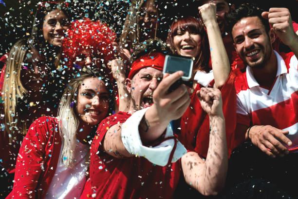 istock Group of Fans Taking a Video 967998696