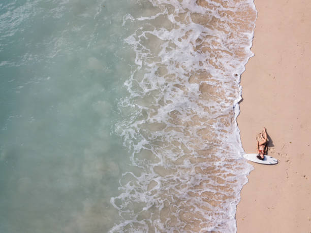 istock Surfer woman on sandy beach washed by the ocean 968009084