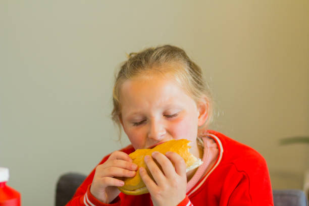 istock girl eating a bratwurst sausage 968009098