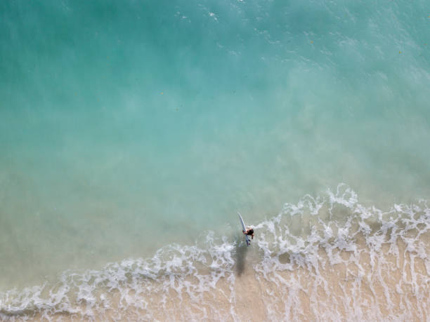 istock Woman with surfboard walking into the ocean 968009182