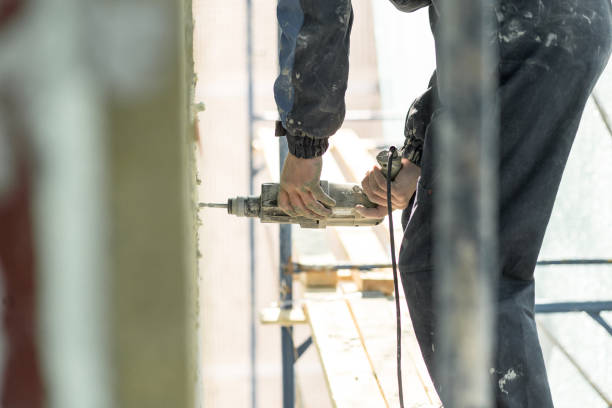 istock Hand drilling on the scaffolding on altitude. Concept repairing the wall panel 968009580