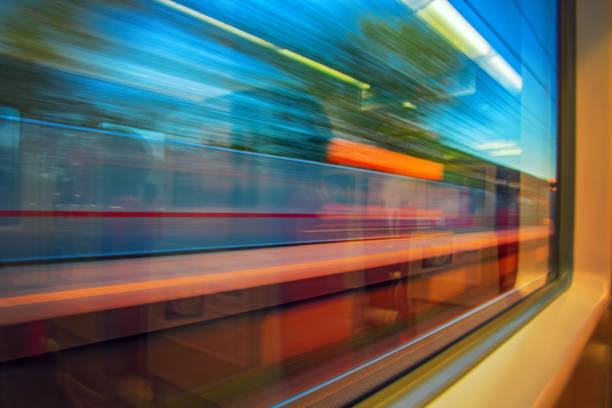 Abstract motion-blurred view from a moving train. Motion blur view from the window of a fast moving high speed train. Concept traveling by rail, blurred lights and nature. Looking out of the window.