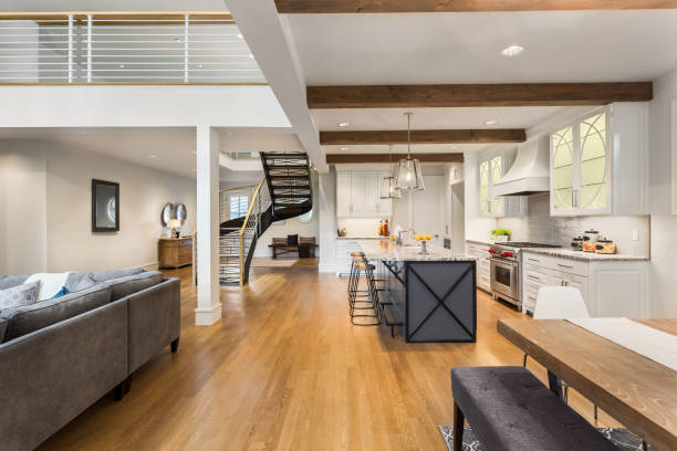 istock Beautiful luxury home interior with open concept floorplan. Shows kitchen, dining room, living room, and entry with stairscase 968025434