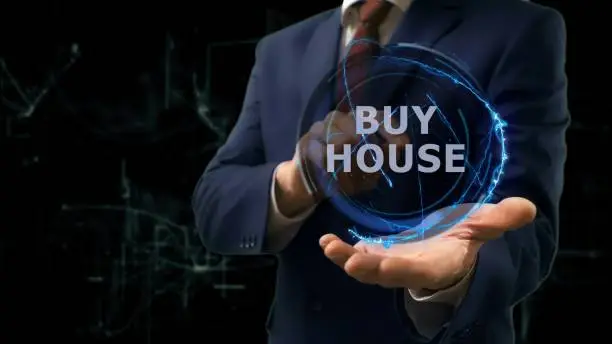 Photo of Businessman shows concept hologram Buy house on his hand