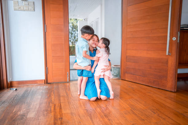 istock Mother hugging her children when coming home 968062706