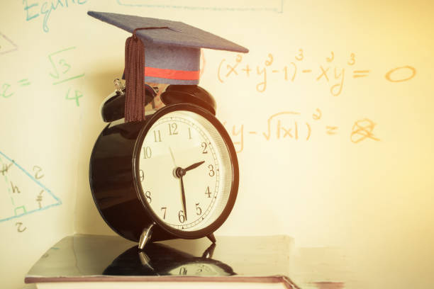 istock Graduation cap on top retro alarm clock with math formula equation graph on screen classroom. Ideas for abroad international Educational and times Studies lead to success in life, Back to School 968067596