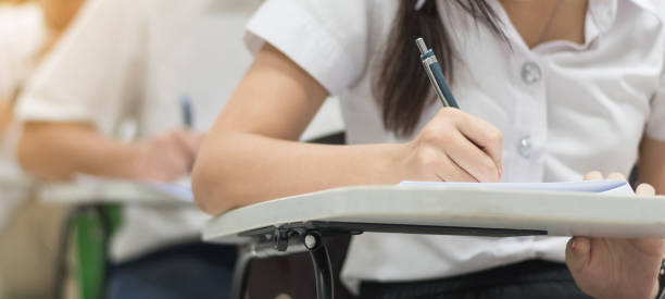 istock School exam, education concept with student taking examination or admission test writing answer in classroom with stress 968086434