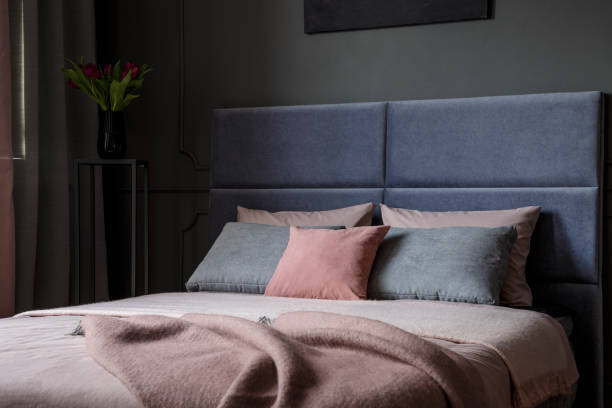 Pink and grey bedroom interior Close-up of pink and grey pillow on bed with blanket and headboard in bedroom interior head board bed blue stock pictures, royalty-free photos & images