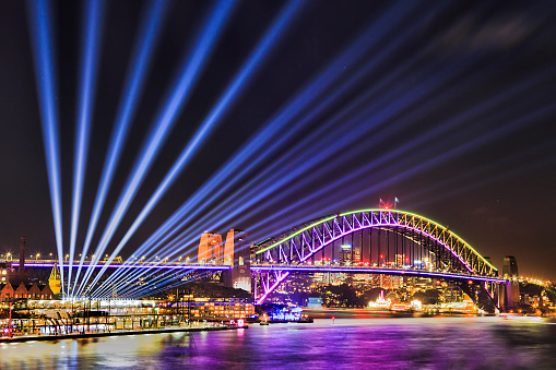 Vivid sydney festival of light and ideas in Sydney city CBD around Harbour with light beams off the Harbour bridge from circular Quay.