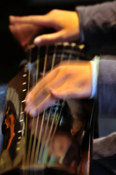 Hand of Chinese woman playing guzheng