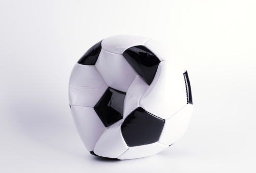 One deflated soccer ball on white background