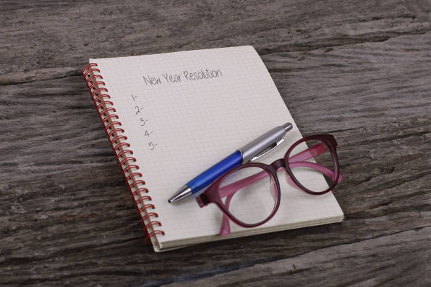 istock Top view of notebook written New Year Resolution on wooden background. 968197022