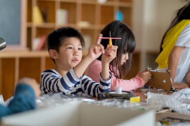 giovane gruppo di studenti che sperimentano una lezione di ingegneria - primary produce foto e immagini stock