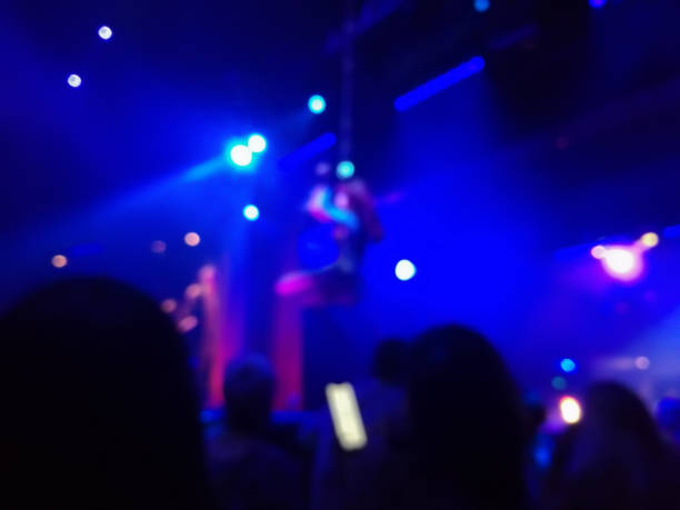 istock Defocused abstract blurred scene of musical light performance in a concert on stage with crowd 968216276