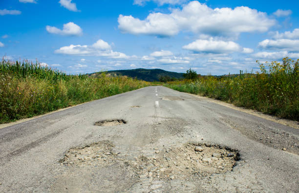 悪い道路ひび割れ - pot hole ストックフォトと画像