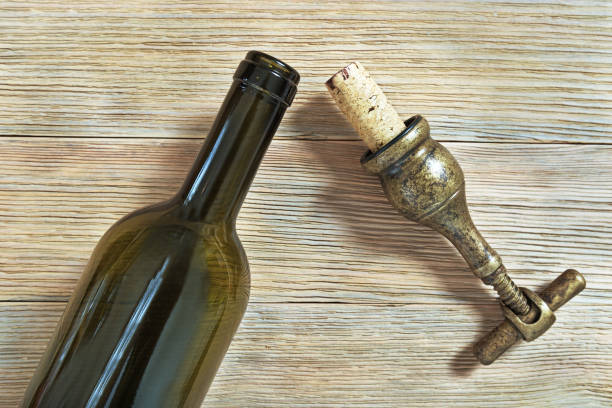 istock Bottle of red wine open with a metal corkscrew on wood 968229072