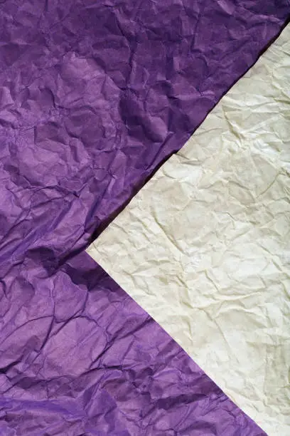 Background of wrapping crumpled paper of two colors is white and purple. Wrinkled Packaging Paper. Vertical format.
