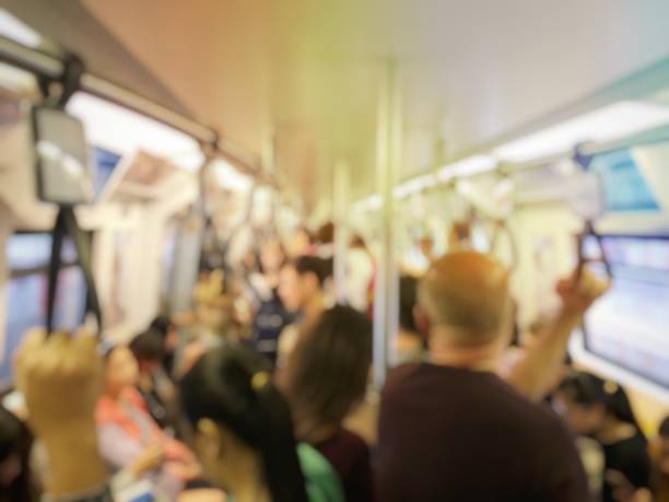 istock blurred image of people standing and sitting and passenger hand holding handle on the train of the public transport. interior abstract background. 968231876
